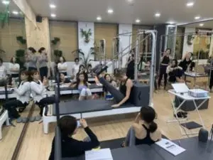 Erin Myers showing a stretch on Pilates reformer during a scoliosis training in South Korea